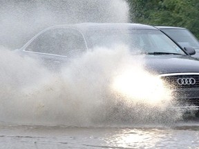 Vehicle heads through heavy rain and flooding. (file photo)