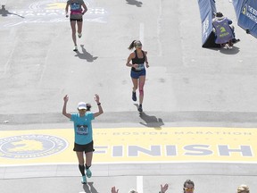 Arms raised in celebration and wearing bib number 22072, Algonquin College's Pembroke campus librarian Patti Kim crosses the finish line of the Boston Marathon on April 18 in a time of 4 hours, 7 minutes and 57 seconds. Submitted photo