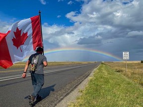 Chad Kennedy holds a Canadian flag for a practice walk across Southern Alberta in Sept 2020, in preparation for the current trek across Canada to raise awareness of PTSD.