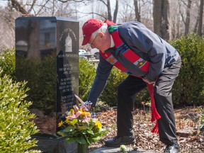 Rev. Scott Boughner places a flower next to a memorial for workers killed on the job. Boughner lead a prayer on Thursday, Workers' Memorial Day, during a community gathering organized by the Stratford District Labour Council. Chris Montanini/Stratford Beacon Herald