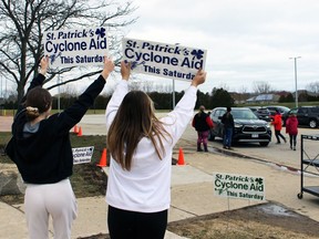 Lauren Armstrong, left, and Emily Orr, both Grade 9 St. Patrick's Catholic high school students, hold up signs during the school's Cyclone Aid food drive for Sarnia's Inn of the Good Shepherd on Saturday, April 9, 2022 in Sarnia, Ont. Terry Bridge/Sarnia Observer/Postmedia Network