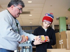 Myles Vanni, executive director of the Inn of the Good Shepherd, and Matthew Borody, a Grade 6 St. Anne Catholic elementary school student, sort donations during the Cyclone Aid food drive for Sarnia's Inn of the Good Shepherd on Saturday, April 9, 2022 in Sarnia, Ont.  Terry Bridge/Sarnia Observer/Postmedia Network