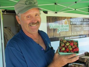 Allan Williamson, of Williamson Farms in Lambton Shores, is shown in this file photo holding a box of strawberries during Thursday's Moonlight Farmers' Market in Waterfront Park in Point Edward. Village officials are reaching out to potential vendors interested in being part of the market this spring.