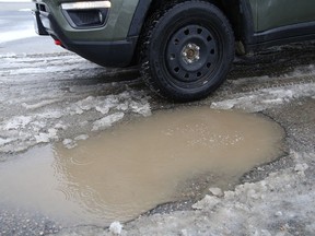 Potholes and large crater-size holes cover Stafford Street in New Sudbury on March 31.