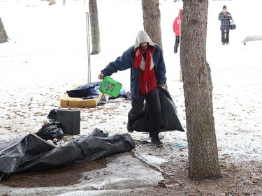 A man collects his belongings from an encampment at Memorial Park in Sudbury, Ont. on Friday April 1, 2022. The City of Greater Sudbury set a deadline of April 1, 2022 for occupants of the encampment to leave the park. The City said in a short email that fencing was being erected "in the area of the encampment to allow for maintenance work and ground restoration to begin over the coming weeks/months." John Lappa/Sudbury Star/Postmedia Network