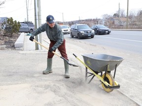 Jimmy Egan cleans up sand that accumulated over the winter at a local business on Lorne Street in Sudbury, Ont. on Wednesday April 6, 2022. John Lappa/Sudbury Star/Postmedia Network