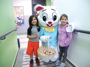The Easter bunny poses for a picture with Liam Corbiere-Madahbee, left, and Isabel Hogg-Mines during a visit to Adamsdale Public School in Sudbury, Ont. with Ward 11 Coun. Bill Leduc on Wednesday April 13, 2022. Leduc said the chocolate goodies were donated by the Real Canadian Superstore. The Easter bunny and Leduc will be busy for the next several days visiting Westmount Retirement Residence, Finlandia and Extendicare Falconbridge on Thursday, as well as Lot 88 on Friday from 6 p.m. to 9 p.m. where proceeds from chocolate martinis sold will go to support the people of Ukraine. They will visit Birkdale Village and Carmichael complex on Saturday. John Lappa/Sudbury Star/Postmedia Network