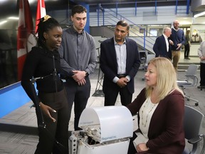 Sudbury MP Viviane Lapointe, right, tries out the IRegained MyHand System advanced prototype as IRegained Inc. team members Margot Shima, left, Eric Dumais and Vineet Johnson, president and CEO, look on following a funding announcement  on Thursday. Lapointe announced $528,550 in FedNor funding to support the commercialization of IRegained's hand rehabilitation device for stroke survivors.