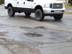 A driver swerves to avoid a number of potholes on Lansing Avenue in Sudbury, Ont. John Lappa/Sudbury Star/Postmedia Network