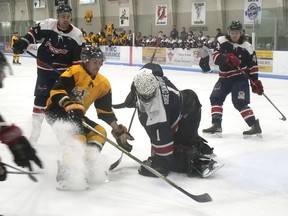 Elora Rocks goalie Colin Dunne covers up the puck under pressure from Tillsonburg Thunder's Derek Slaght. Elora won Saturday's game 3-2 to clinch the WOSHL championship. CHRIS ABBOTT