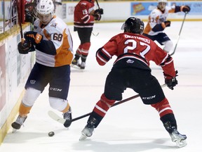 Ethan Hay tries to dance around Cedricson Okitundu in the first period as the Owen Sound Attack host the Flint Firebirds in Game 4 of their Western Conference best-of-seven quarterfinal series inside the Harry Lumley Bayshore Community Centre on April 27, 2022. Greg Cowan/The Sun Times