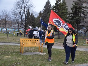 Demonstrators march from Memorial Park toward Tom Davies Square on Sunday afternoon as part of a May Day gathering that called on candidates in the upcoming provincial election to value workers and their families.