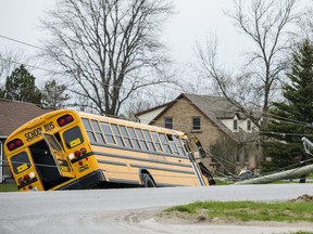 A school bus lays on its side after hitting a hydro pole Tuesday afternoon near in intersection of Farnham Road and Kipling Drive in Belleville, Ontario. ALEX FILIPE