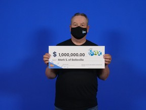 Belleville resident Mark Sensenstein holds up a cheque for his $1 million Lotto Max win. Submitted