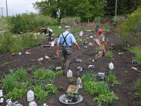 Memories of a typical garden scene at planting time are from a previous season. This gardener took a break from transplanting and steps forward to greet Sara and Sid Scarecrow. (Ted Meseyton)