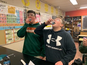 Ty Hall and Travis Micallef take a swig of a little Powerade for the process of extracting DNA from their cheeks. STEAM students in grades 9 and 10, as well as grades 11 and 12 biology students at West Ferris Intermediate and Secondary School, were treated to a lesson by a student ambassador funded by the Natural Sciences and Engineering Council of Canada.