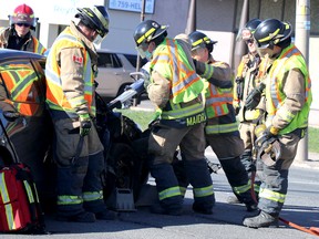 Firefighters use the Jaws of Life to remove a door following a two-vehicle crash at Great Northern Road and Wawanosh Avenue in Sault Ste. Marie, Ont., on Friday, May 6, 2022. (BRIAN KELLY/THE SAULT STAR/POSTMEDIA NETWORK)
