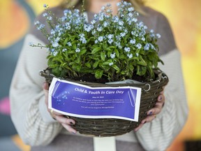 Teri-ann MacDonald holds a basket of forget-me-nots, the official flower of the Children and Youth in Care Day. The #ForgetMeNot campaign is about sharing the stories of young people with experience in the system and reminding community, government, and service providers that these young people continue to need critical supports. They cannot be forgotten. Wednesday at the Highland Shores Children's Aid Society in Belleville, Ontario. ALEX FILIPE