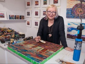 Stratford artist Kim McCarthy working in her home studio on a mixed media piece called Emergence. The painting, with an accompanying poem by Heidi Sander and music by Paul Shilton, will be part of a roaming exhibit in Stratford beginning this July. Chris Montanini/Stratford Beacon Herald.