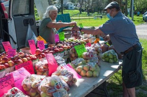 Fred Sapwell buys apples from Melody Arnhold at the St. Marys Farmers' Market on Saturday.  The outdoor market at The Flats is now open for the season, running every Saturday morning until October.  CHRIS MONTANINI/STRATFORD BEACON HERALD