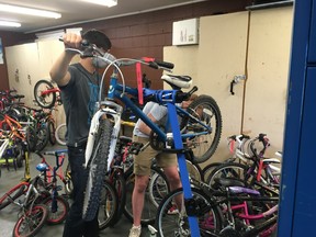 Cutline – Volunteers tune and fix donated bikes for the seventh annual ReCycle Bikes Program. The bikes are distributed to area residents deemed in need by local agencies.