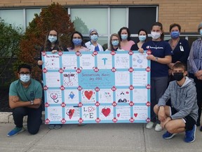 Grade 7 and 8 students at Gregory Drive Public School made a special presentation recently to nurses at Chatham-Kent Health Alliance. Crouching at front are Rudra Patel and Ryan Millington. Behind the sign are Dakota Stover, Stephanie Davidson, clinical education leader, and Charlotte Peco. At back are Lynn Richie, unit clinic leader ICU/PCU, Marcia Walden, manager of professional practice, Erin Dejaegher, occupational health nurse, Jess Casey, professional practice leader, Meredith Whitehead, vice-president of transformation and chief nursing executive, and Lori Marshall, president and CEO. (Trevor Terfloth/The Daily News)