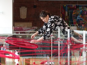 Chambers hard at work installing Hope and Healing at the Douglas Family Arts Centre. Photo by Bronson Carver