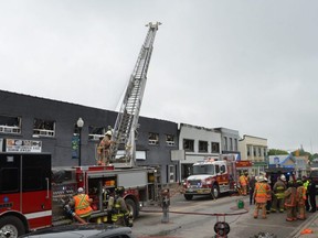 Fire crews pour water on a fire along Hanover's main street late on the morning of Thursday, May 19, 2022.