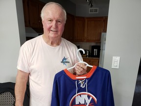 Dave Pulkkinen displays a jersey of the New York Islanders, for whose organization he enjoyed his greatest success in hockey.