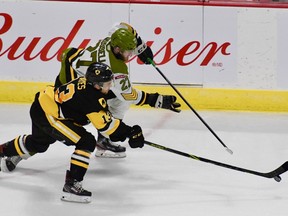 Mitchell Russell of the North Bay Battalion and Avery Hayes of the host Hamilton Bulldogs compete for the puck in Game 2 of their Ontario Hockey League playoff series Sunday night. The best-of-seven set moves to North Bay on Wednesday night.