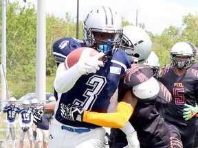 Sudbury Junior Spartans running back Zidaine Allen (3) gets wrapped up by OJ Olubiyi (2) of the Peel Panthers while running the ball during Ontario Summer Football League action at James Jerome Sports Complex in Sudbury, Ontario on Saturday, May 28, 2022.
