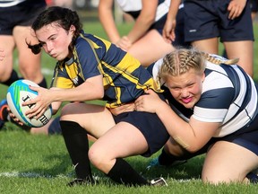 Chatham-Kent Golden Hawks' Carmen Ballesteros Calvo, left, is tackled by Ursuline Lancers' Faith Heynick during the LKSSAA senior girls' rugby final at Ursuline College Chatham in Chatham, Ont., on Thursday, May 19, 2022. Mark Malone/Chatham Daily News/Postmedia Network