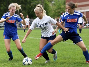 Ursuline Lancers' Katey Kovar, centre, competes for the ball against Sandwich Sabres' Zola DeGraw, left, and Rosalind Canty during the second half of the SWOSSAA senior girls' AAA soccer final at Ursuline College Chatham in Chatham, Ont., on Thursday, May 26, 2022. Mark Malone/Chatham Daily News/Postmedia Network