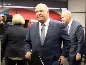 With NDP leader Andrea Horwath and Liberal leader Steven Del Duca behind him, Ontario PC leader Doug Ford departs the Ontario party leaders' debate in Toronto, May 16, 2022.