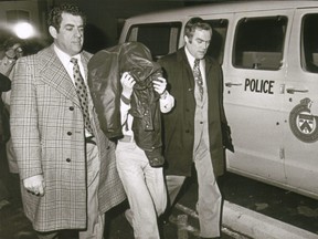 Murder suspect Douglas Lawrence McCaul covered his head as he's led into court during his 1976 trial.