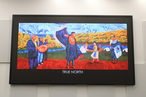True North by Frederick McDonald hangs inside the council chambers at the Jubilee Centre in Fort McMurray on April 25, 2022. The elders drum while three generations of women dancers dance. The animals in the sky represent the seven sacred teachings: love (eagle), honesty (raven), humility (wolf), courage (bear), wisdom (beaver), truth (turtle) and respect (bison). Symbols on the ground show Indigenous people lived off the land, until governments, churches began moving people out of their communities. “With the help of Aboriginal spirituality, today we live strong in our communities and we celebrate all the things that make us who we are with old traditions, along with the help of newly adapted cultural experiences,” writes McDonald. Vincent McDermott/Fort McMurray Today/Postmedia Network