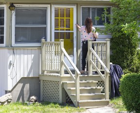 A Lambton County OPP officer knocks on the door of a home as she canvasses a neighbourhood where a 27-year-old Exeter man was fatally stabbed Friday night. Two men and a woman are charged in the homicide. Photo shot on Sunday, May 15, 2022. (Derek Ruttan/The London Free Press)