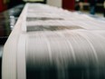 Newspaper being printed on rolls of paper
