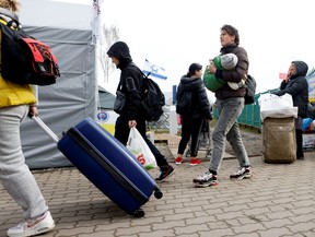 Ukrainian refugees walk after crossing the Ukraine-Poland border, amid the Russian invasion of Ukraine, in Medyka, Poland April 10, 2022. REUTERS/Leonhard Foeger