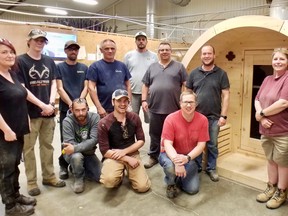 Workers at the former Vokes Furniture company, now True North Saunas, learn about pine wood sauna construction at the company's Springmount shop Wednesday, May 18, 2022. Left to right, back: Nicole Coture, Cole Jones, Mike Richardson, Carl Price, Cliff Price, Paul Oehm, Mike Vokes, Tammy Barry-Murphy, Mike Thomas. Left-to-right, front: Jamie Moseley, William Deboer and Mike Inglis. (Scott Dunn/The Sun Times/Postmedia Network)
