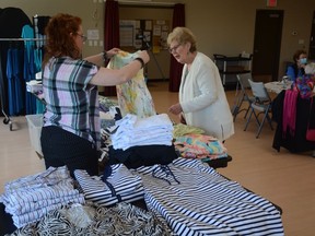 An attendee of Seniors on the Bow's Fashion Show takes a look at garments from Northern Reflections, who were showing off their catalogue on Saturday, May 14. Photo by Riley Cassidy/The Airdrie Echo/Postmedia Network Inc.