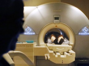 A technologist watches an MRI machine scan a patient at Belleville General Hospital in 2016. Quinte Health Care is offering to help patients book lower-priority MRI and CT scans at neighbouring hospitals as its Belleville and Trenton sites deal with backlogs.
