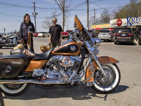 Kelsey McKellar (left) and Mikell Gauvreau of Port Dover stop to admire a Harley Davidson motorcycle as they walk their dogs along Walker Street in Port Dover on Tuesday May 10, 2022 in Brantford, Ontario. The Friday the 13th Gathering at the Lake Erie town this Friday is expected to draw a large crowd with sunshine, warm temperatures and the easing of pandemic restrictions.