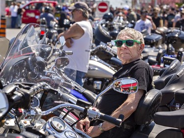 Paul McRobb, 80 of Caledon East sits on his Harley-Davidson as he watches the motorcycles and crowds go by on Main Street during the Friday the 13th Gathering in Port Dover, Ontario. Brian Thompson/Brantford Expositor/Postmedia Network