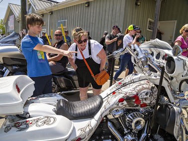 James Allard of Brantford points out some artwork to his mother Tiffany Short as they take in the sights and sounds of the Friday the 13th Gathering in Port Dover, Ontario. The Day of the Dead-themed 2017 Harley-Davidson Street Glide, owned by Chantal Leonard of Ottawa drew a lot of attention to passersby. Brian Thompson/Brantford Expositor/Postmedia Network