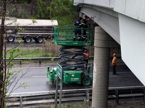OPP measure the height of the North Park Street bridge over Highway 403 where it was struck Wednesday by a passing vehicle.