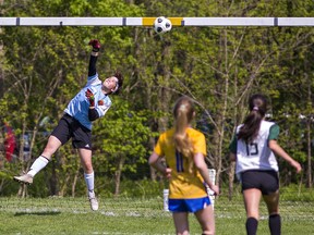 BCI Mustangs goalkeeper Olivia Saylon leaps to try to block a shot by Alessia DiNino (right) of the St. John's Eagles during the Athletic Association of Brant, Haldimand and Norfolk high school girls soccer final on Thursday.