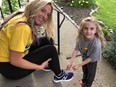 Hope Jennions, 6, helps her mom Abbey Ball with her laces before a training session. Ball is among 10 Brantford and area residents who will be walking 100 kilometres in 24 hours in support of her daughter and others who live with cystic fibrosis. VINCENT BALL