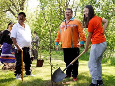 Karonhyakeha, 13, helps plant a tree alongside Stacey Laforme (centre), elected chief of the Mississaugas of the Credit First Nation, and residential school survivor Alfred Johnson during a commemorative tree planting ceremony Tuesday to honour and remember survivors of the former Mohawk Institute residential school in Brantford. COLE BURSTON/AFP via Getty Images