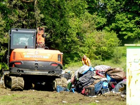 Workers clear out a homeless encampment by Highway 401 in Brockville on Tuesday morning, May 31, 2022. (RONALD ZAJAC/The Recorder and Times)